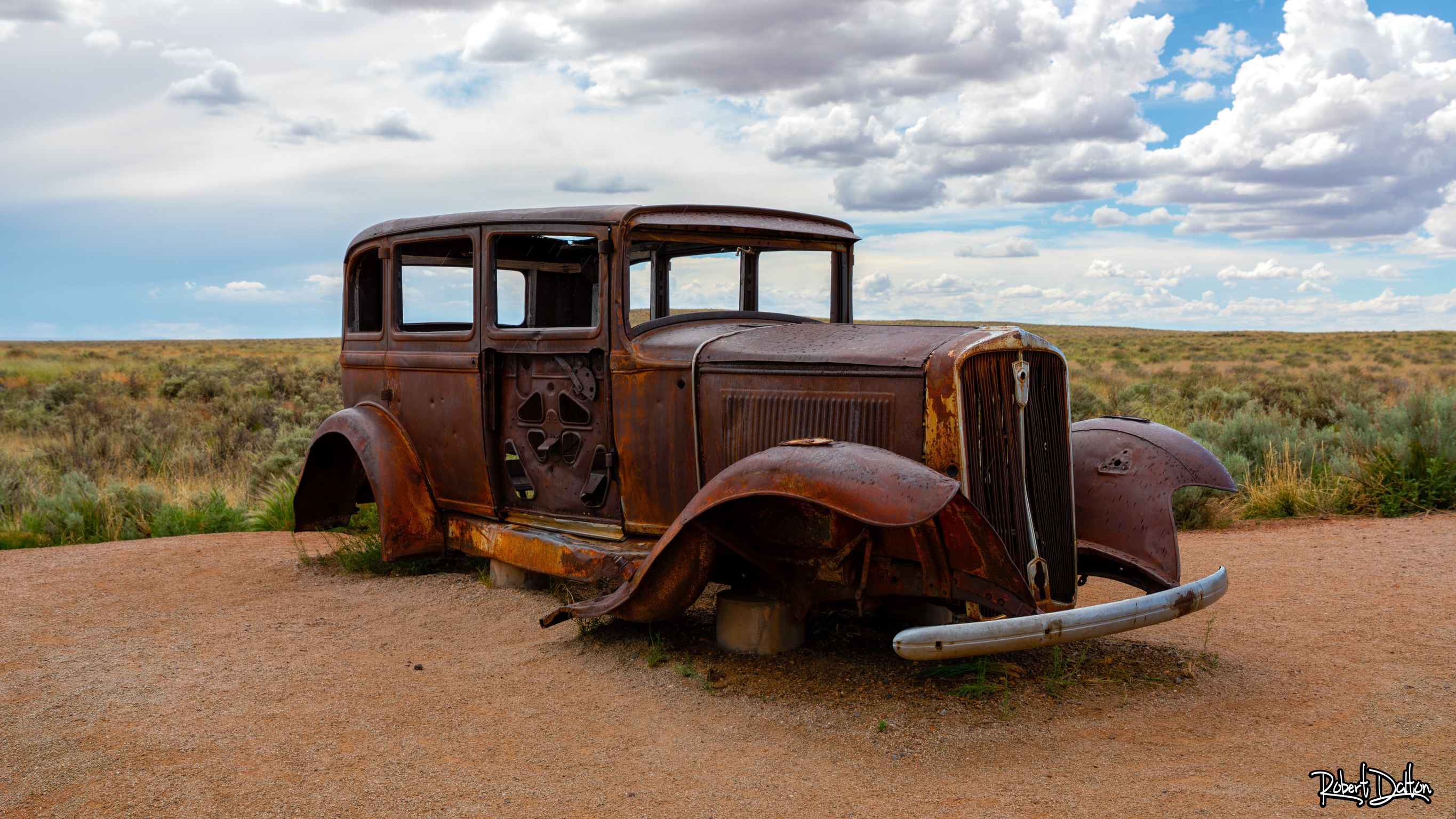 ROUTE-66-DENKMAL UND 1932ER STUDEBAKER IN DER GEMALTEN WÜSTE